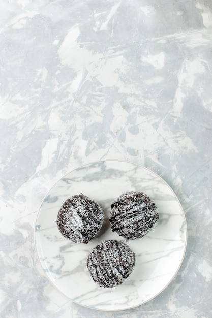 Vista superior distante, deliciosas bolas de chocolate redondas com cobertura em uma mesa branca clara assar bolo torta de chocolate doce