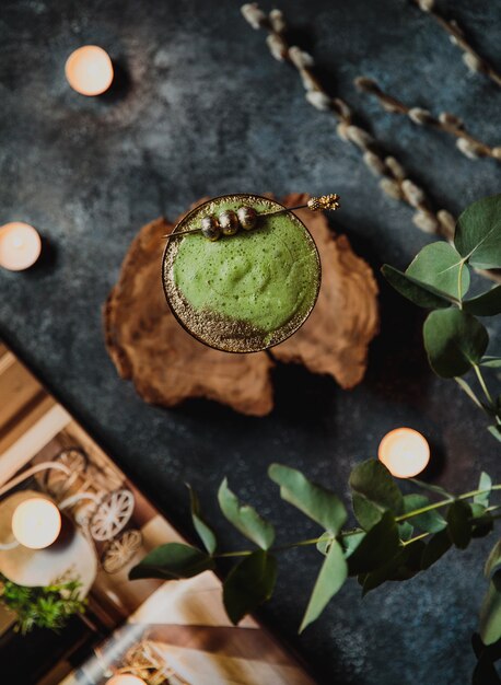 Vista superior do álcool cocktail com kiwi em um copo de ouro em um carrinho de madeira