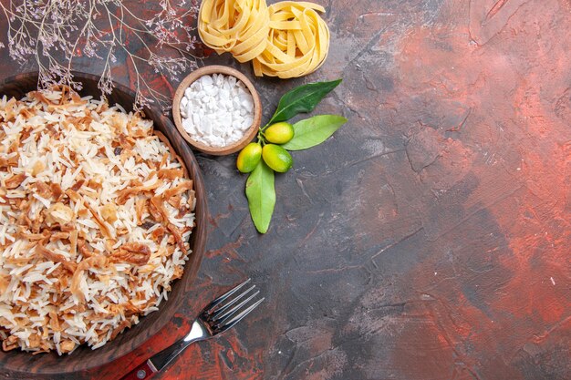 Vista superior do arroz cozido com fatias de massa na superfície escura foto de prato de refeição escura