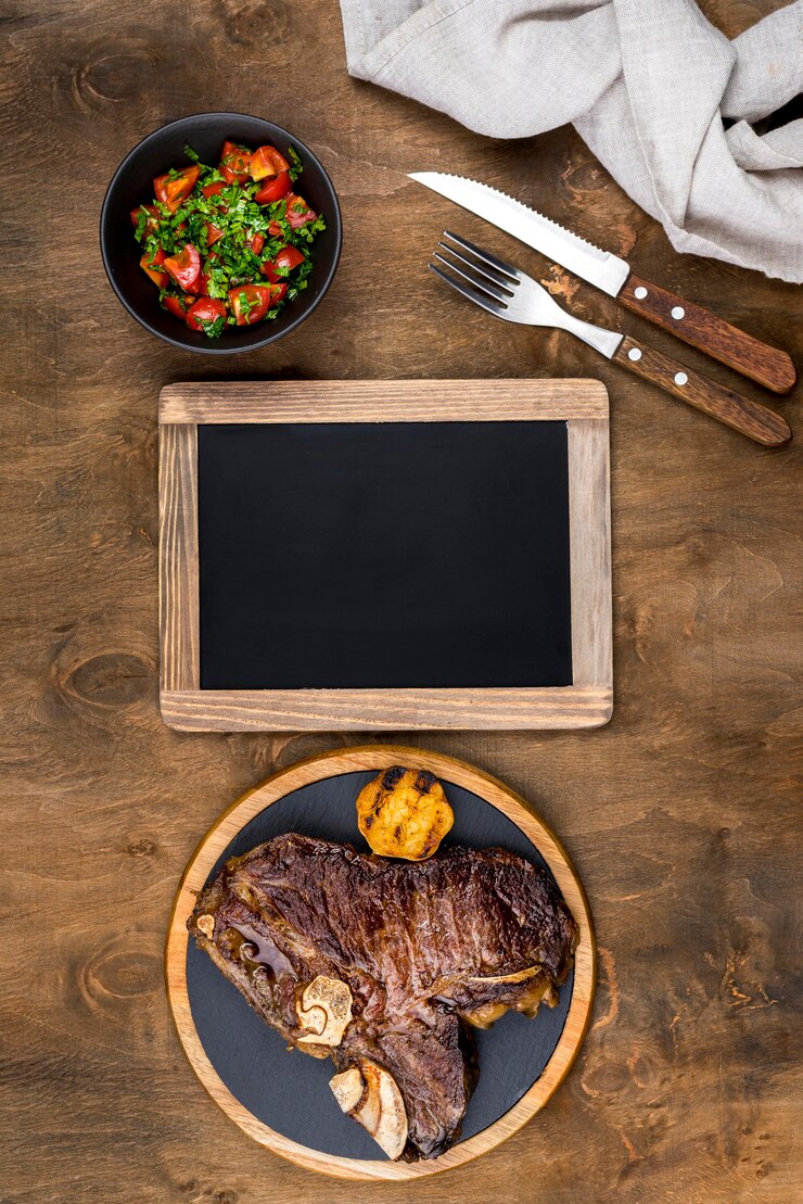 Foto grátis vista superior do bife no prato com salada e quadro-negro