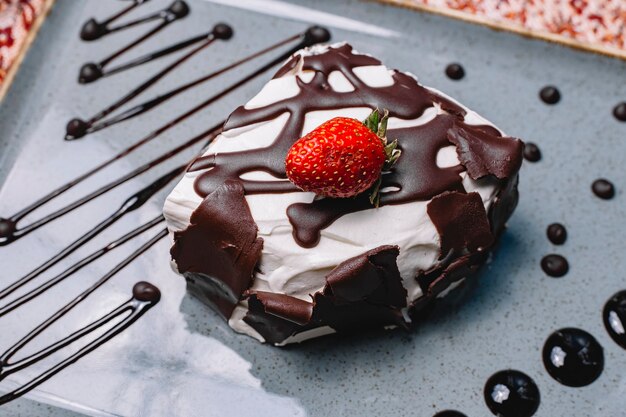 Foto grátis vista superior do bolo cremoso branco decorado com pedaços de chocolate e morango por cima