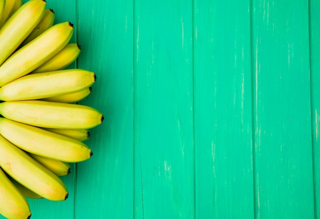 Foto grátis vista superior do cacho de bananas, isolado na madeira verde, com espaço de cópia