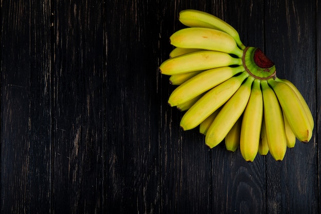 Vista superior do cacho de bananas na madeira preta com espaço de cópia