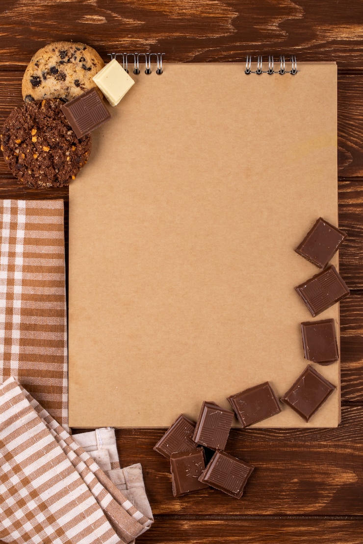 Foto grátis vista superior do caderno com pedaços de chocolate escuros e biscoitos de aveia no fundo de madeira