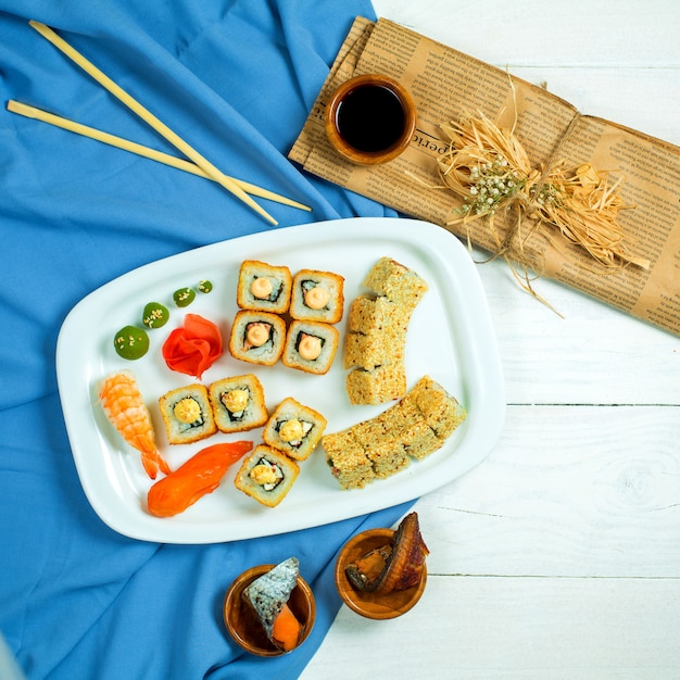 Foto grátis vista superior do conjunto de sushi e maki com molho de soja em azul e branco