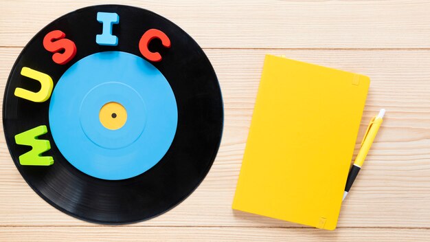 Vista superior do disco de vinil e notebook em fundo de madeira