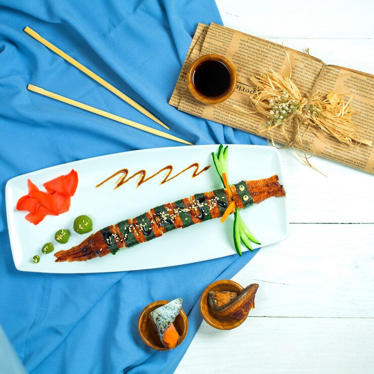 Foto grátis vista superior do dragão de sushi tradicional culinária japonesa com pepino enguia e abacate em azul e branco