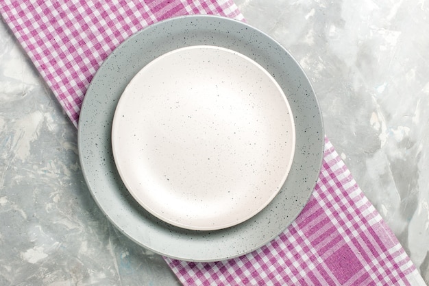 Vista superior do prato redondo vazio de cor cinza com placa branca na superfície cinza