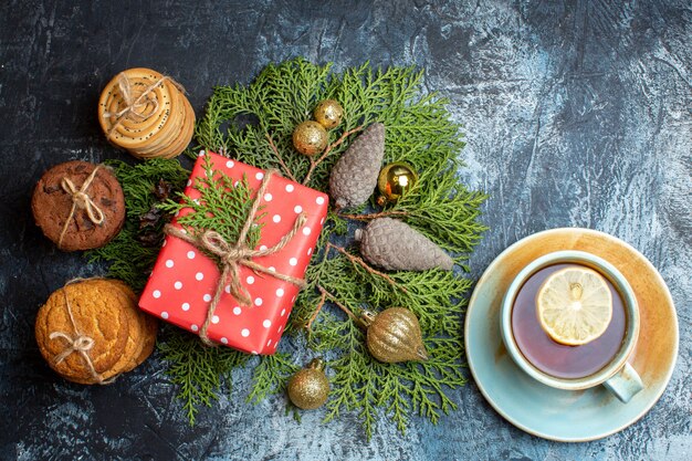Vista superior do presente de natal com biscoitos diferentes e uma xícara de chá