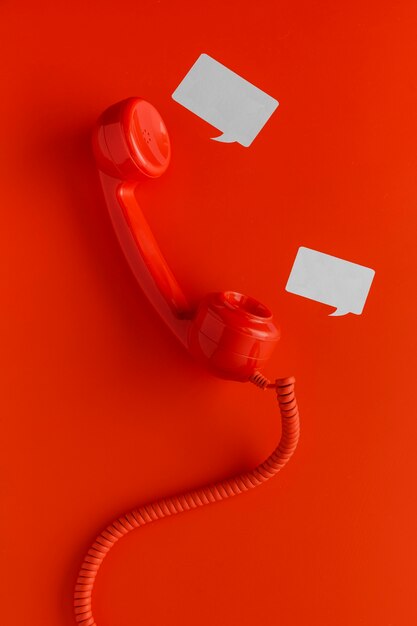 Vista superior do receptor de telefone com cordão e bolhas de bate-papo