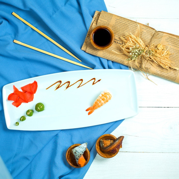 Foto grátis vista superior do sushi nigiri japonês tradicional com camarão servido com molho de soja e gengibre com wasabi em azul e branco