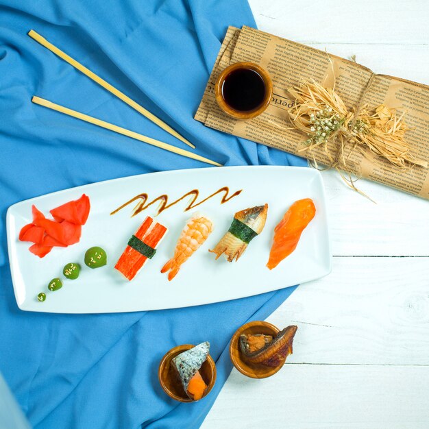 Vista superior do sushi nigiri japonês tradicional com enguia de salmão de atum e camarão em azul e branco