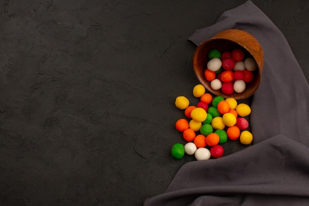 Foto grátis vista superior doces coloridos gostoso dentro pote marrom no escuro