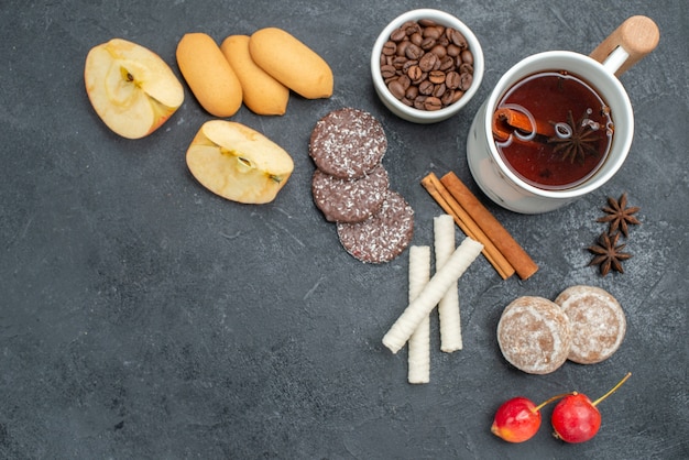 Vista superior em close-up biscoitos de chá uma xícara de chá canela em pau cerejas de anis estrelado grãos de café