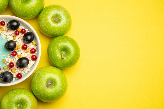 Vista superior em close-up com frutas, as apetitosas frutas, aveia na tigela, maçãs verdes