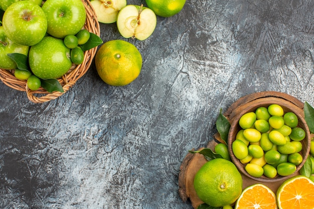 Vista superior em close-up da cesta de maçãs com maçãs verdes no tabuleiro com frutas cítricas