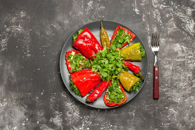 Vista superior em close-up do prato de pimentas os apetitosos pimentões pimentões com garfo de ervas