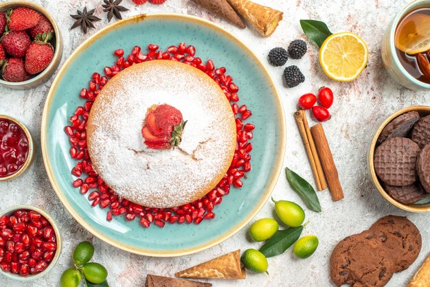 Vista superior em close-up doces biscoitos de chocolate uma xícara de chá com limão um bolo canela e frutas limões