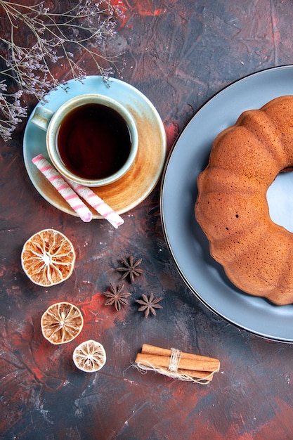 Vista superior em close-up um prato de bolo de bolo uma xícara de chá limão anis estrelado e canela doces