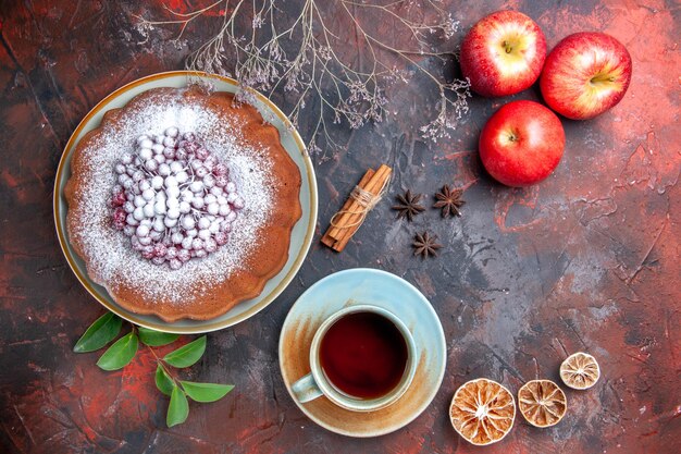 Vista superior em close-up uma xícara de chá uma xícara de chá um bolo com frutas maçãs cítricas anis estrelado