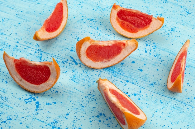 Vista superior em fatias de laranja suculenta madura sobre o fundo azul brilhante