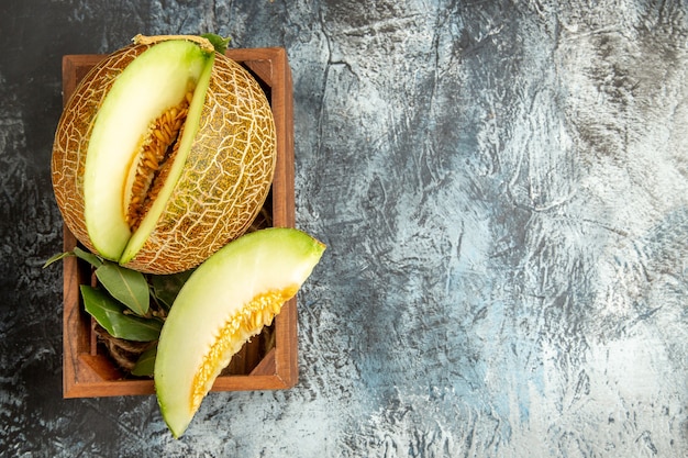 Vista superior em fatias de melão fresco na mesa com luz escura doce fruta doce verão