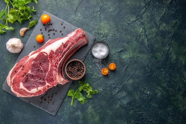 Vista superior fatia de carne fresca carne crua com pimenta e verduras em fundo escuro cor de farinha de frango comida animal foto açougueiro