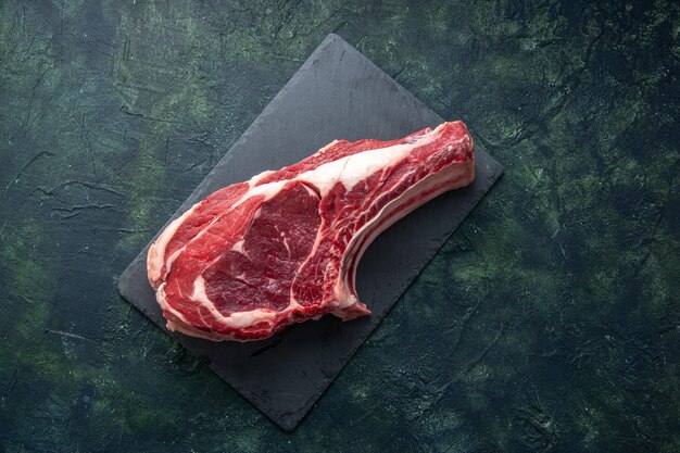 Vista superior fatia de carne fresca carne crua em fundo escuro açougueiro comida animal vaca foto a cores refeição frango