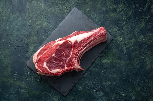 Vista superior fatia de carne fresca carne crua em fundo escuro açougueiro comida animal vaca foto a cores refeição frango