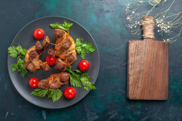Foto grátis vista superior fatiada de carne cozida com vegetais e tomates-cereja vermelhos na superfície azul-escura