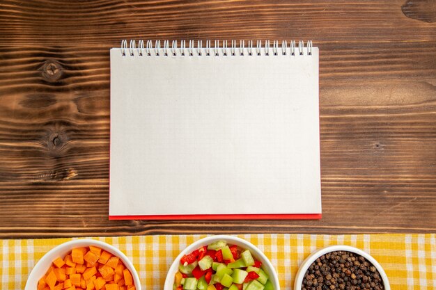 Vista superior fatiada de pimentão com temperos na mesa de madeira marrom salada de vegetais alimentares