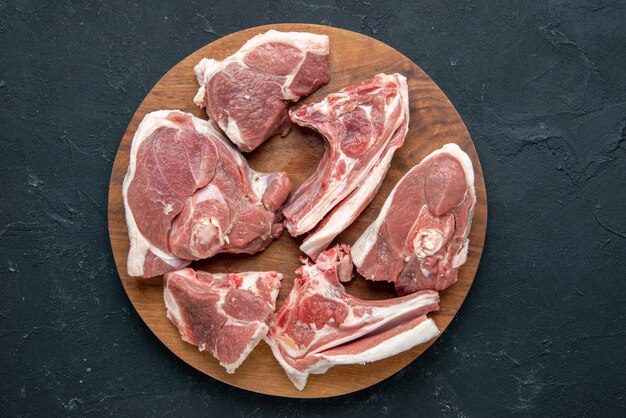 Vista superior fatias de carne fresca carne crua em mesa redonda de madeira na cozinha de comida de comida escura frescura animal vaca refeição