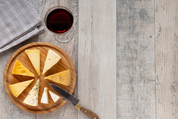 Foto grátis vista superior fatias de queijo e um copo de vinho