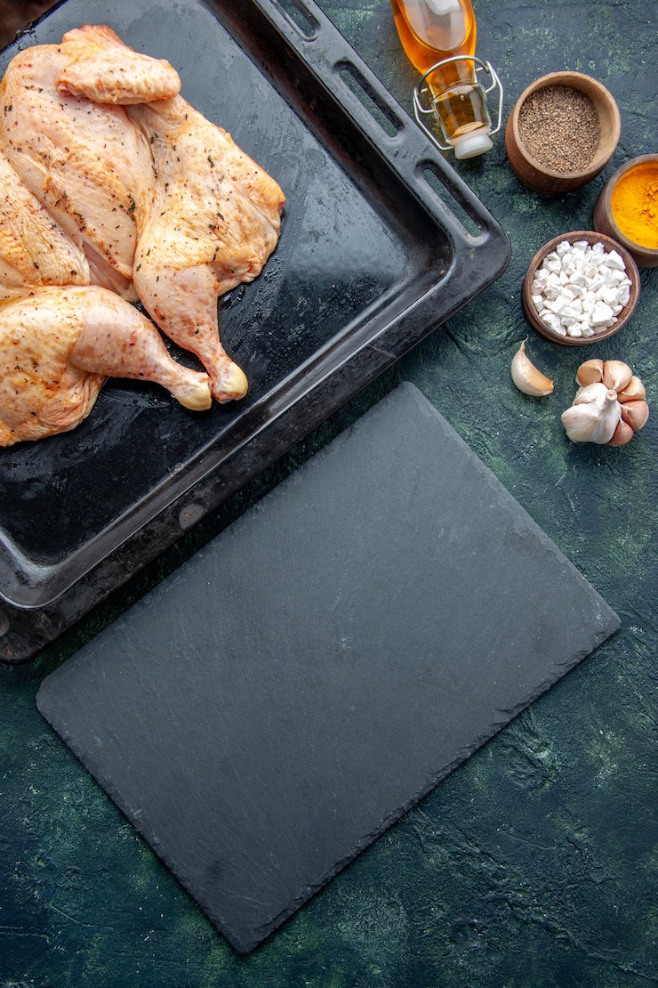 Foto grátis vista superior frango fresco com temperos e temperos em fundo azul escuro.
