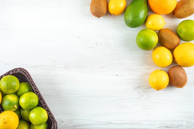 Vista superior frutas cítricas na cesta com espaço de cópia na mesa branca