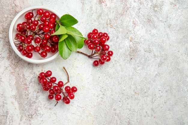 Vista superior frutas frescas de cranberries vermelhas na mesa branca frutas vermelhas frescas