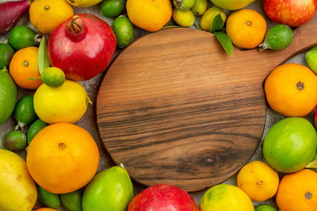 Vista superior frutas frescas diferentes frutas maduras e maduras no fundo branco cor da baga saborosa foto de saúde