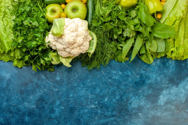 Foto grátis vista superior legumes e frutas pepino salsa endro pimentões alface maçãs couve-flor no fundo azul