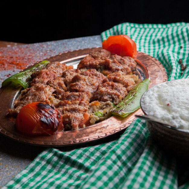 Vista superior lule kebab com salada de berinjela com tomate e papel e ayran