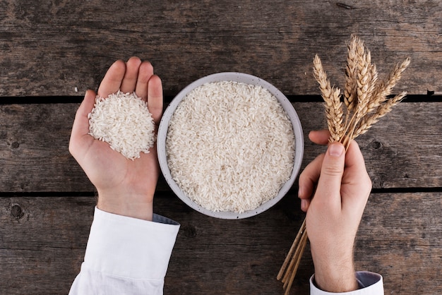 Foto grátis vista superior mãos segurando arroz e grãos