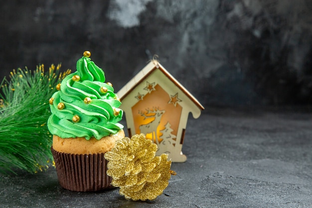 Vista superior mini cupcake árvore de natal lanterna de ramo de árvore de natal pinha dourada em fundo escuro lugar livre