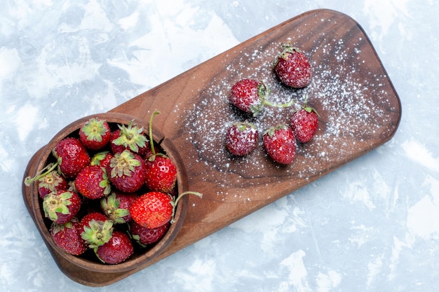 Vista superior, morangos vermelhos frescos e frutas silvestres suaves na mesa de luz