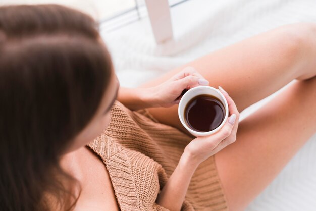 Vista superior mulher segurando uma xícara de café