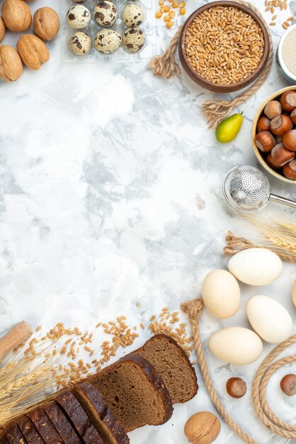 Vista superior pão escuro com ovos de farinha de nozes e leite no fundo branco foto cor bolo torta pão quente massa de biscoito