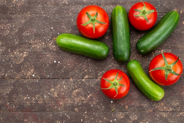 Vista superior pepinos verdes frescos e maduros com tomates vermelhos em marrom, comida de árvore de planta vegetal