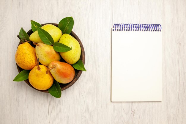 Vista superior peras frescas maduras frutas doces dentro do prato na mesa frutas amarelas frescas doces maduras