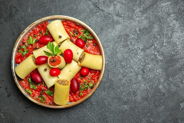 Vista superior refeição deliciosa de massa italiana cozida com carne e molho de tomate no fundo cinza