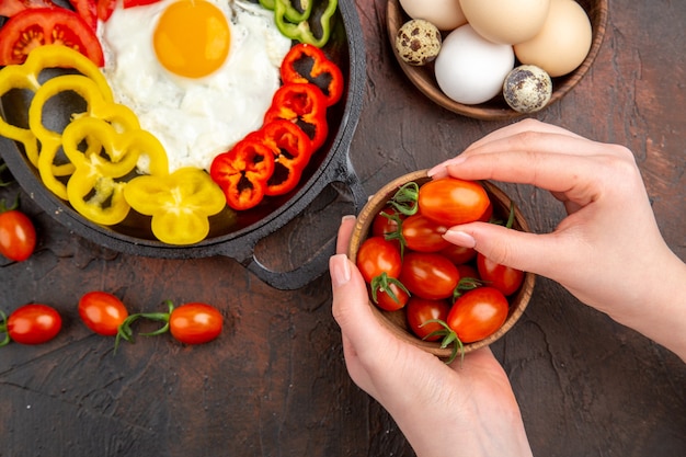 Vista superior saborosa omelete com tomate e pimentão fatiado na mesa escura