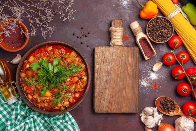 Vista superior saborosa refeição com molho de vegetais cozidos com diferentes temperos e tomates em fundo escuro comida molho refeição prato sopa