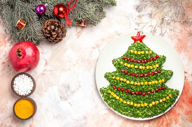 Vista superior saborosa salada verde em formato de árvore de ano novo com temperos em fundo claro